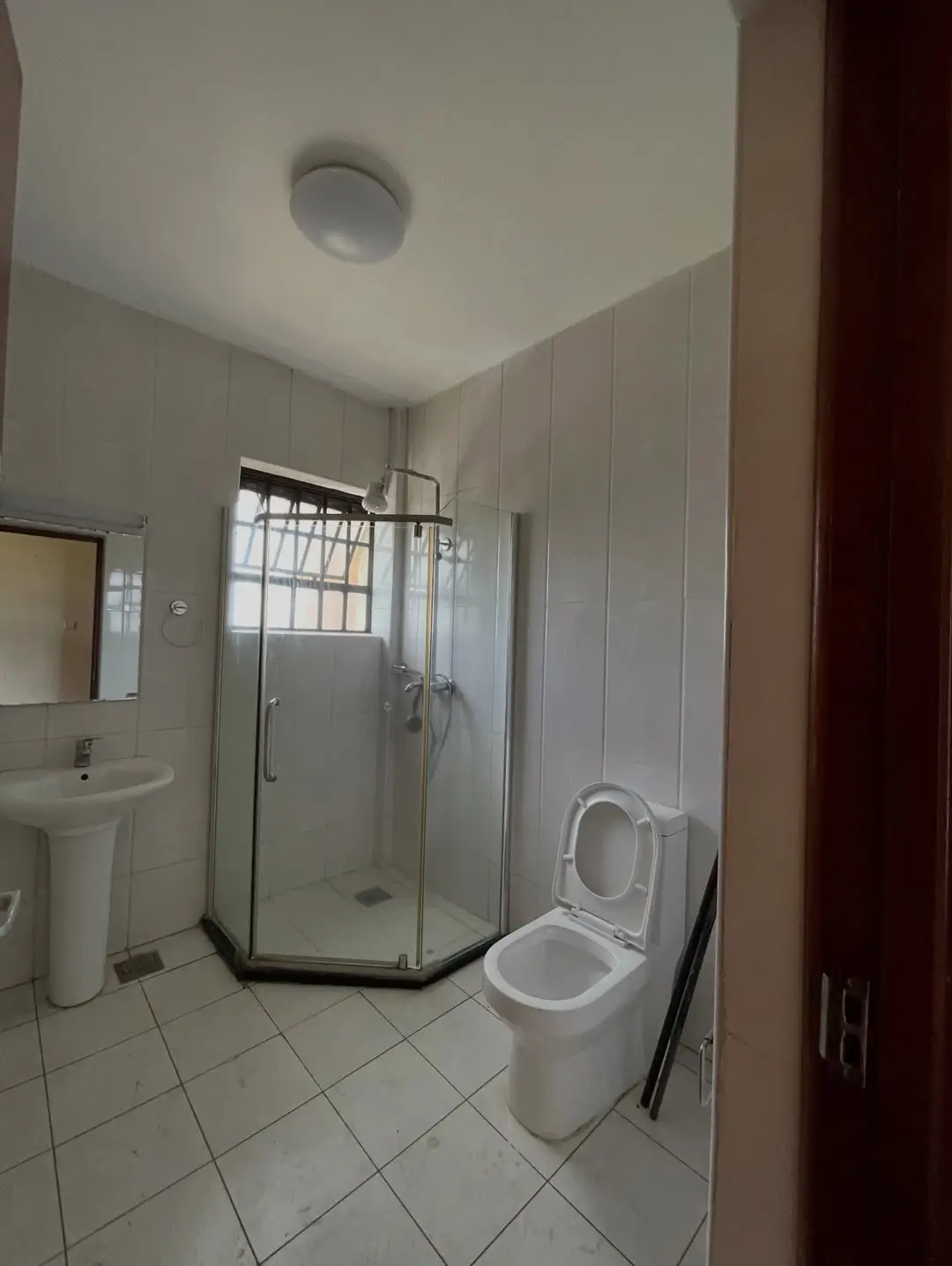 Clean bathroom with walk-in shower, toilet, and pedestal sink