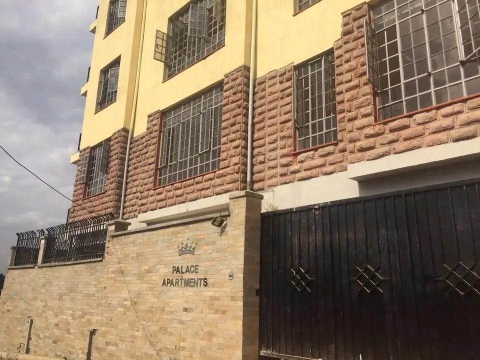 Multi-story residential building facade with brick and cream render