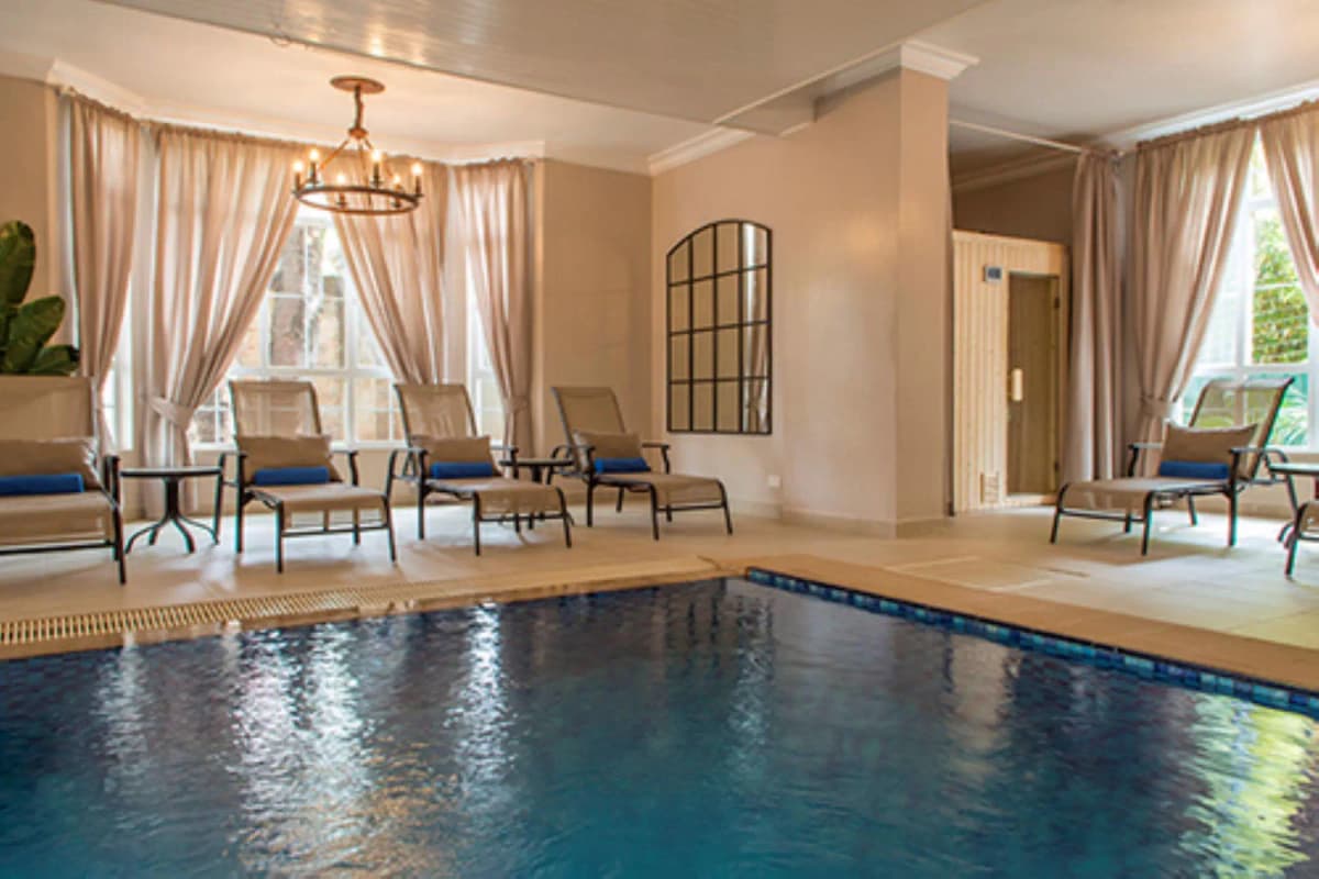 Indoor swimming pool with lounge seating and natural light