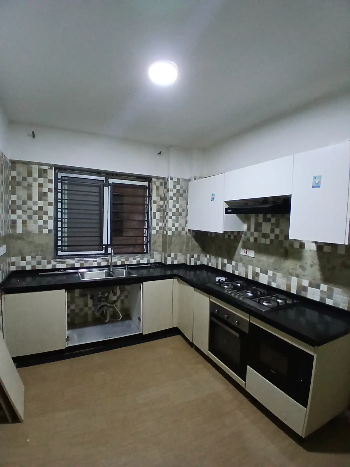 Modern L-shaped kitchen with black granite counters and tile backsplash