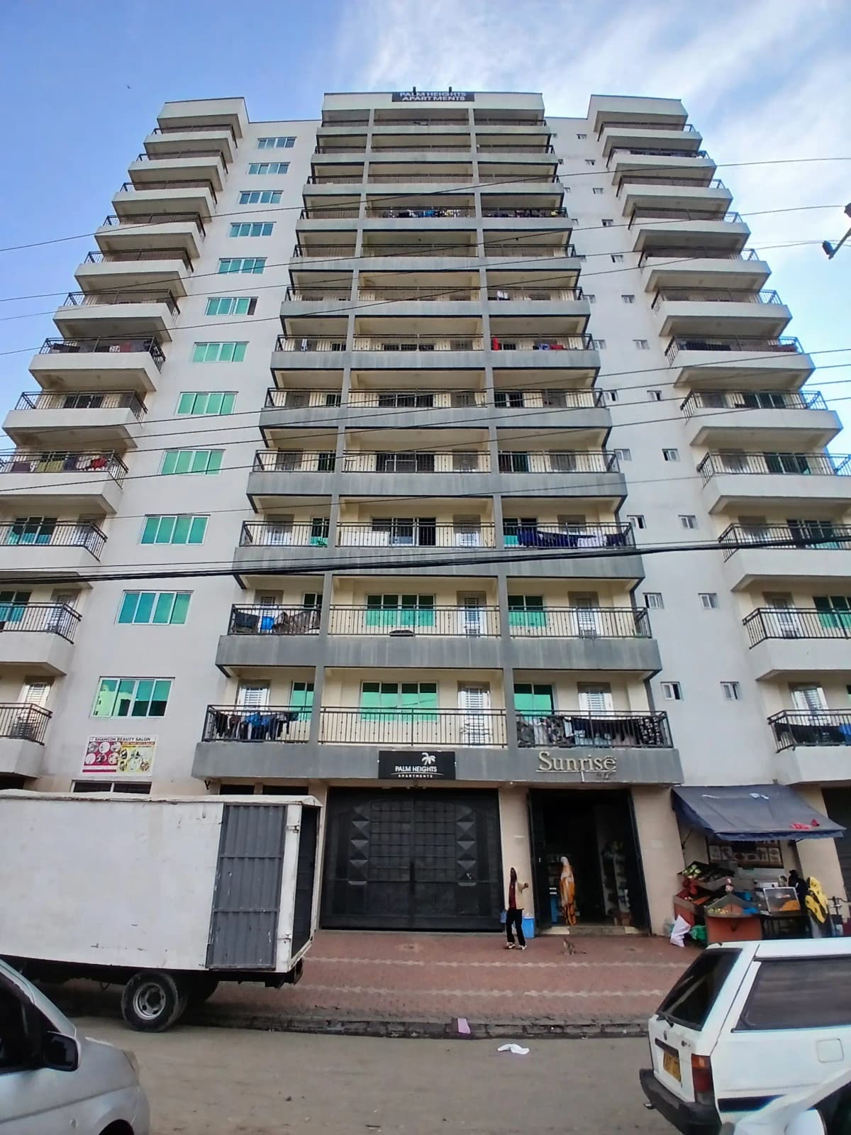 Multi-story residential apartment building with balconies and ground-floor shops