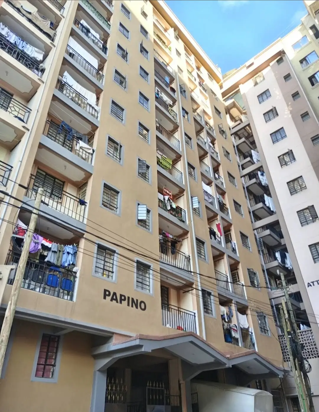 Multi-story residential building facade with balconies and ground-floor retail