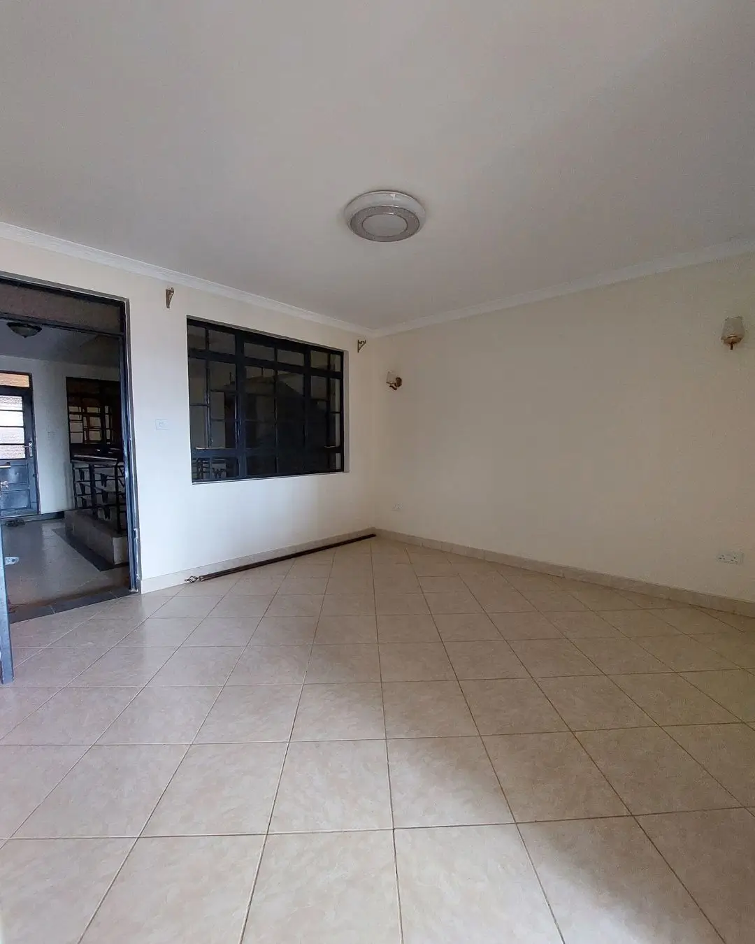Spacious open-plan living area with tiled flooring and recessed lighting