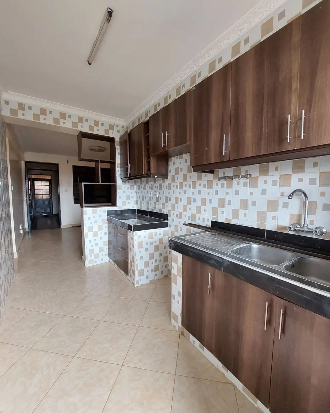 Modern kitchen with dark wood cabinetry and geometric tile backsplash