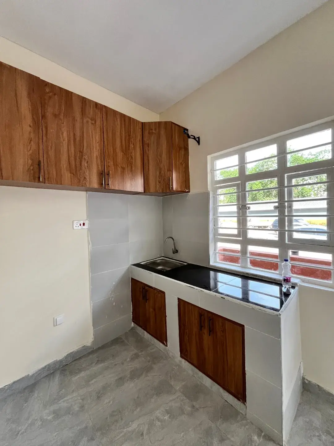 Compact kitchen with wood cabinets and black sink counter
