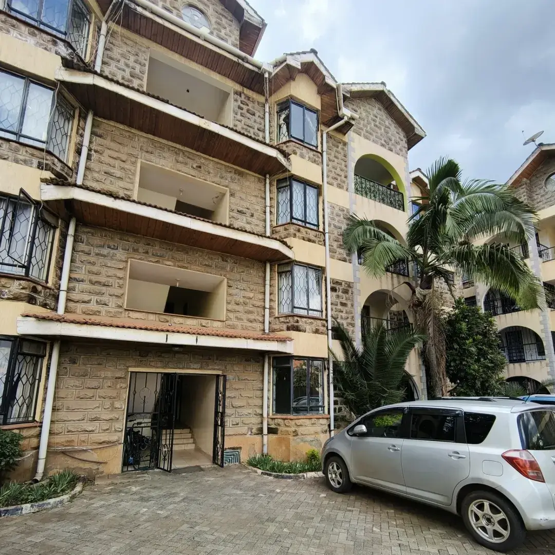 Multi-story residential building facade with parked vehicle