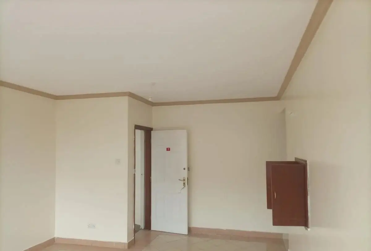 Empty bedroom with white door and brown cabinet