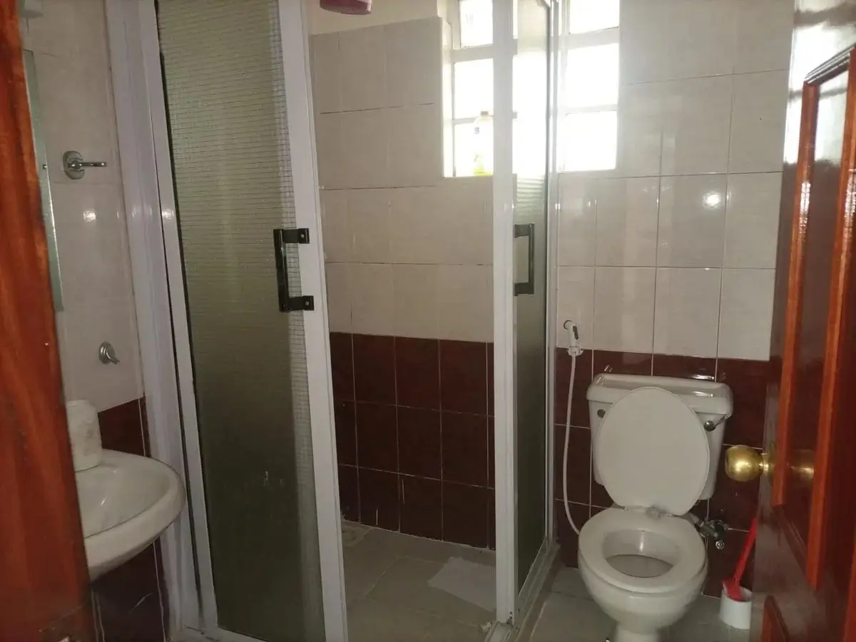 Modern bathroom with walk-in shower and white tile walls