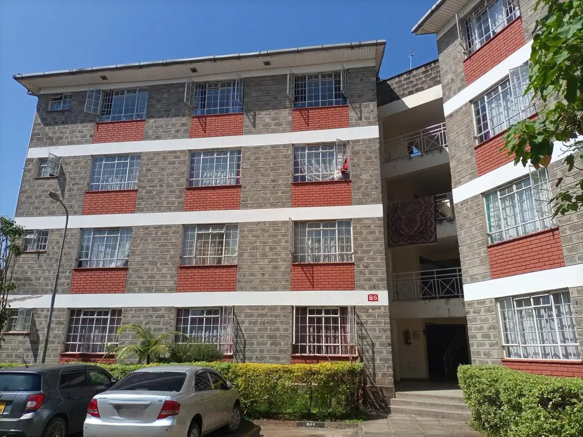 Multi-story residential building facade with red brick accents