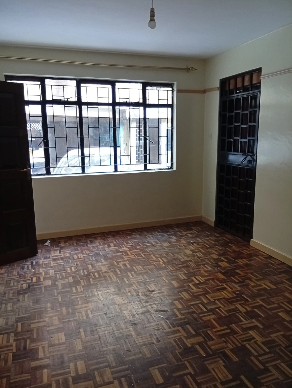Spacious living room with large windows and herringbone flooring