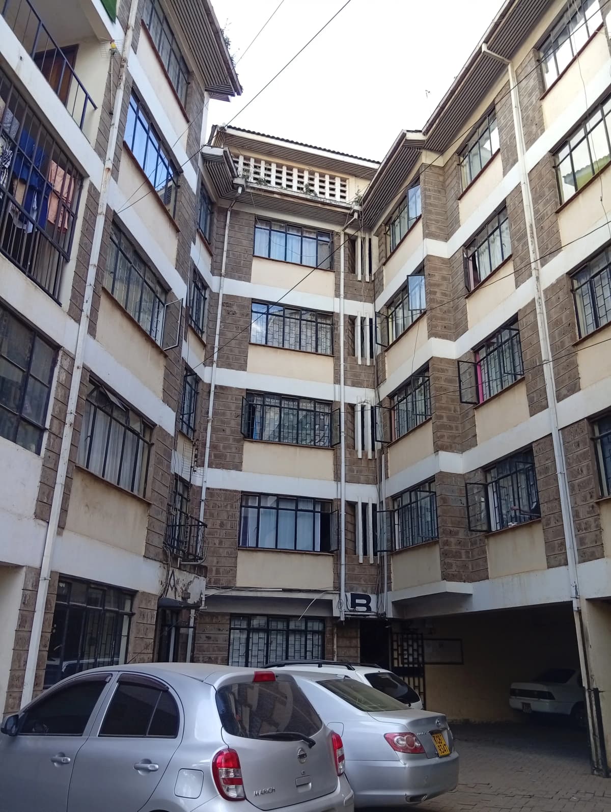 Modern multi-story residential building with secure ground-level parking