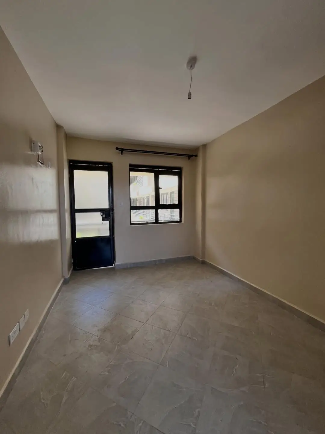 Spacious empty bedroom with glass door and natural light