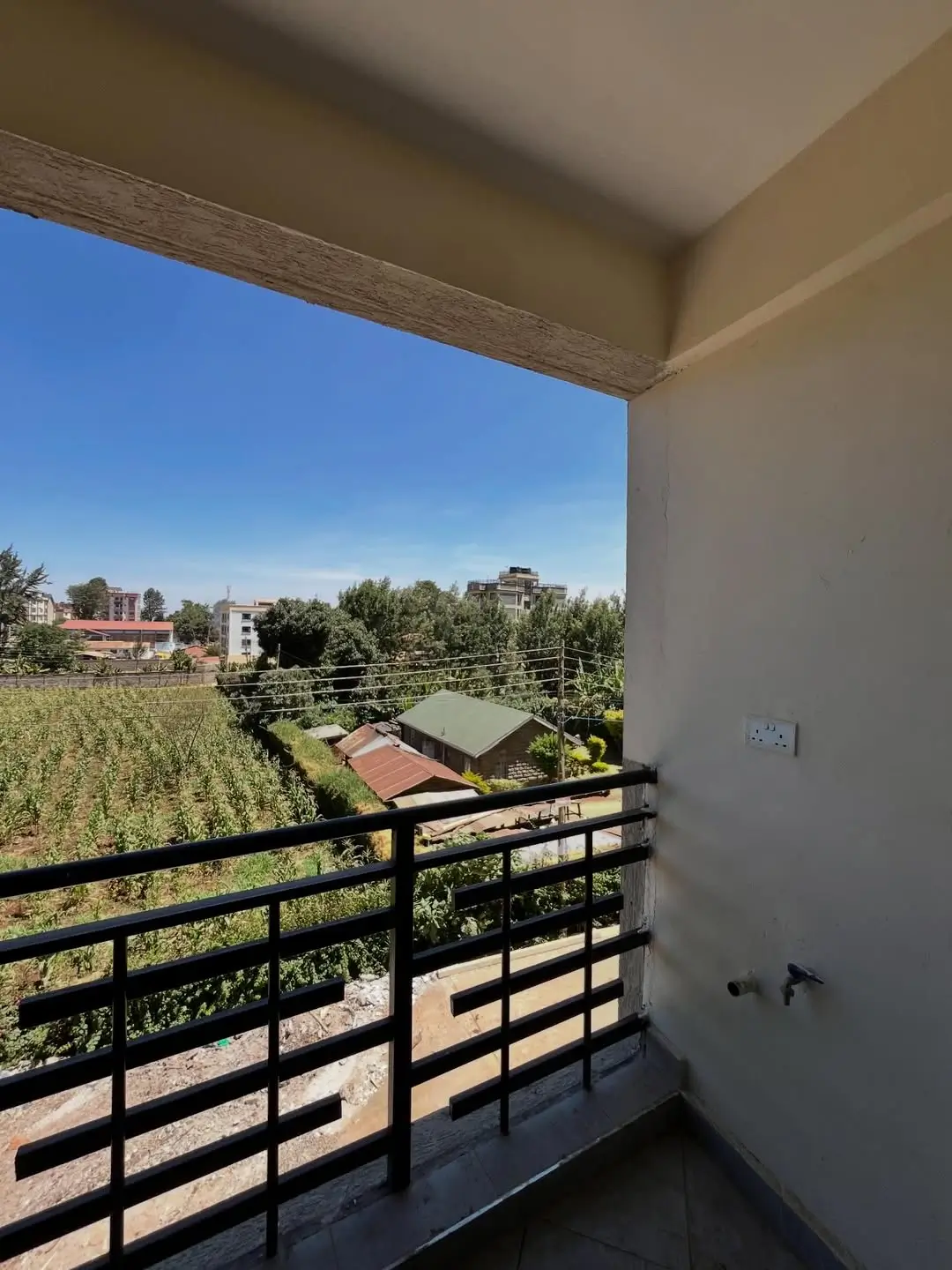 Balcony with city views and agricultural fields beyond