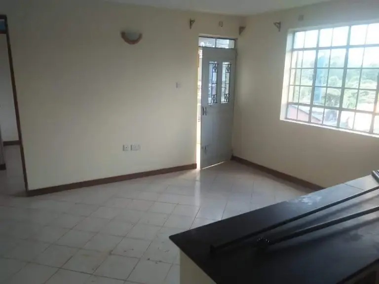 Spacious living room with large windows and tiled flooring