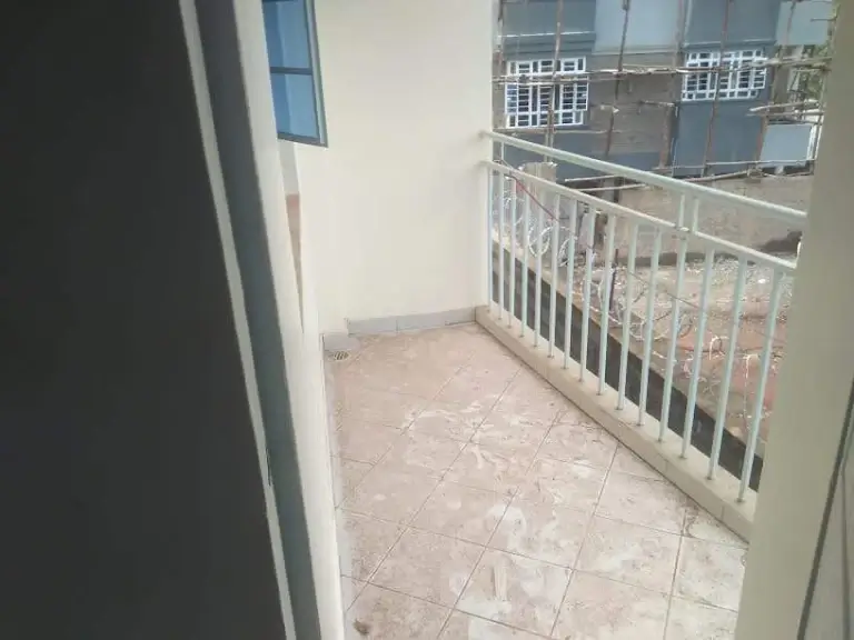 Spacious balcony with white railing and city views