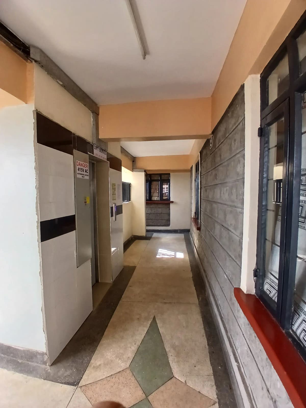 Building corridor with multiple unit doors and neutral tiling