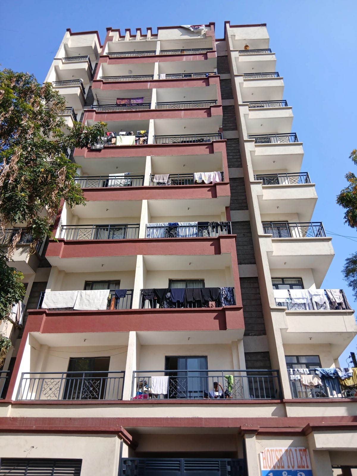 Multi-story residential building facade with balconies and red accents