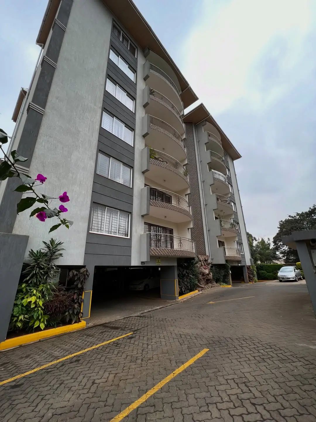 Modern multi-story residential building with basement parking entrance