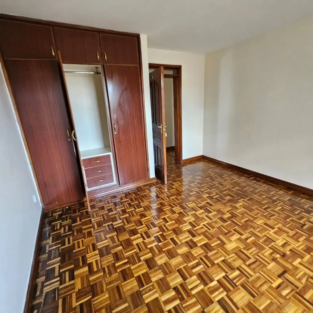 Spacious bedroom with built-in wardrobe and parquet flooring