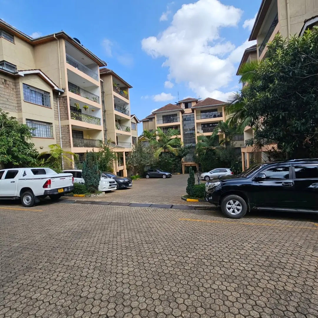 Residential compound parking area with multi-story apartment buildings