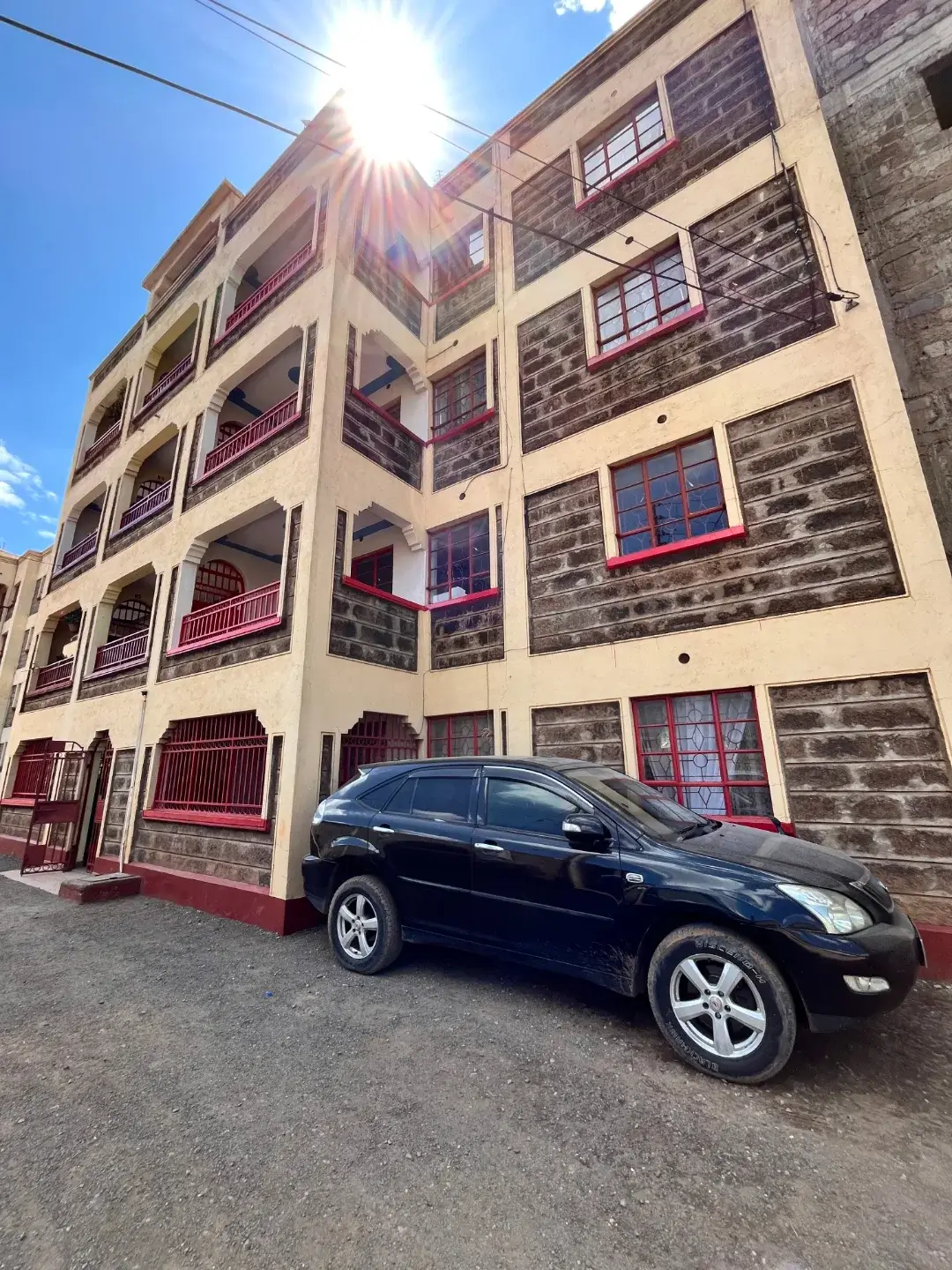 Multi-story residential building facade with parking bay