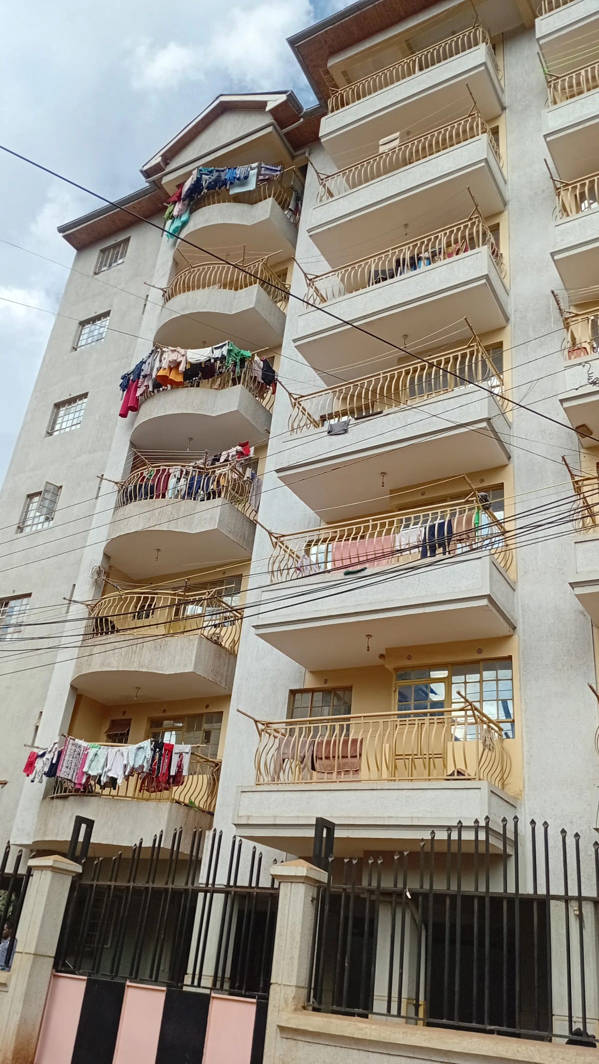 Multi-story residential building facade with balconies and gate