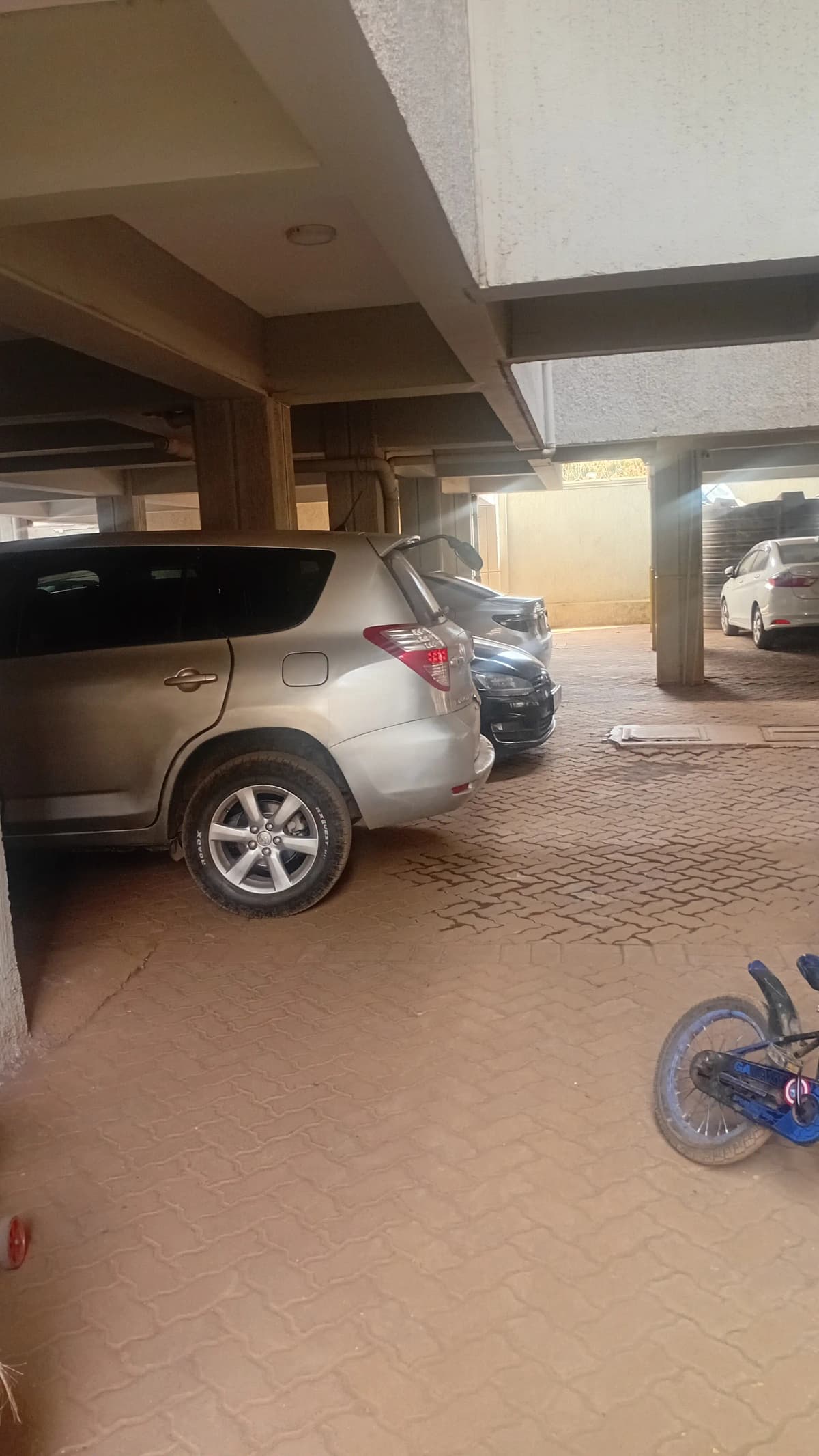 Covered parking bay with two vehicles under carport