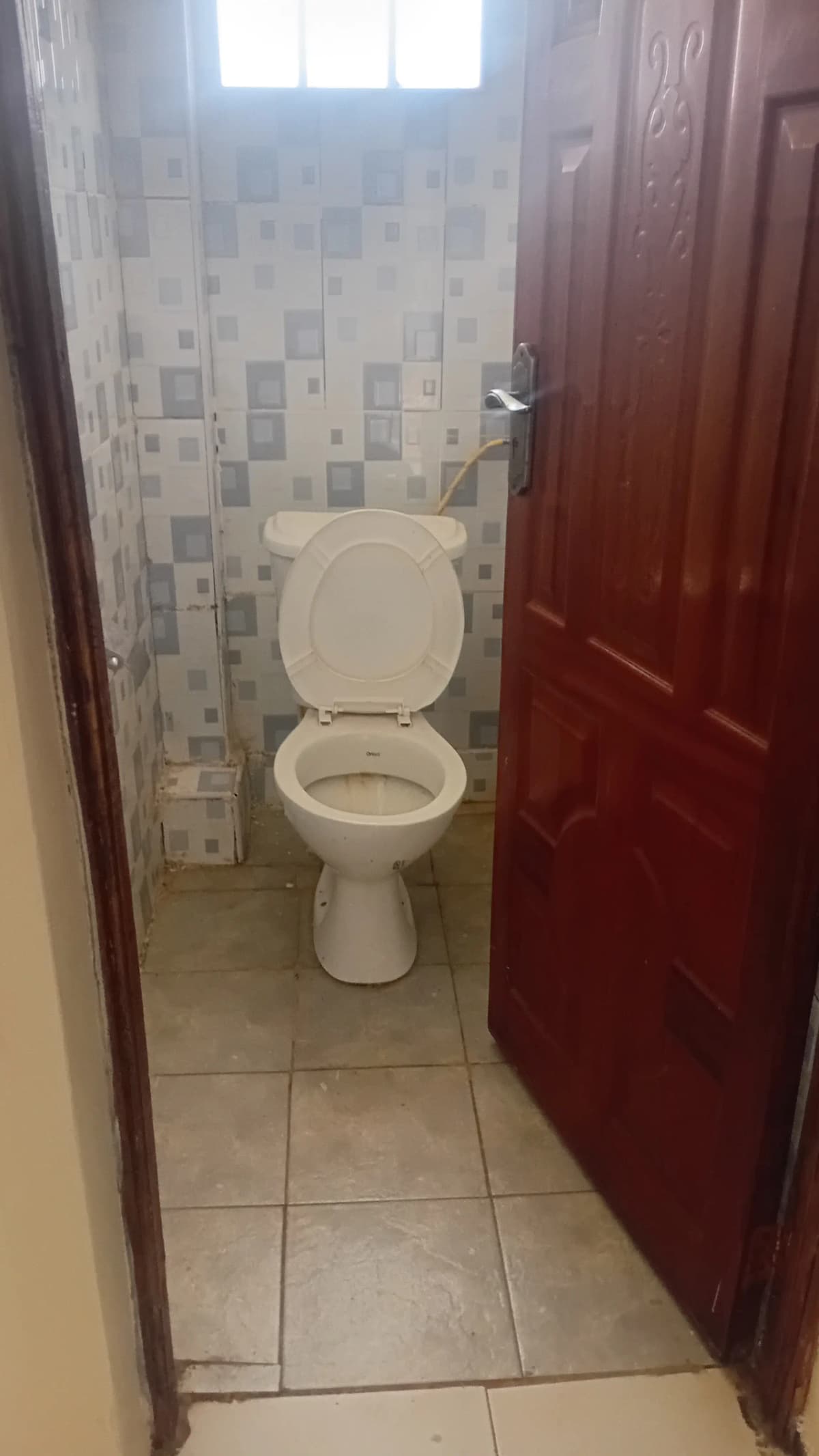 Compact bathroom with toilet and mosaic tile walls