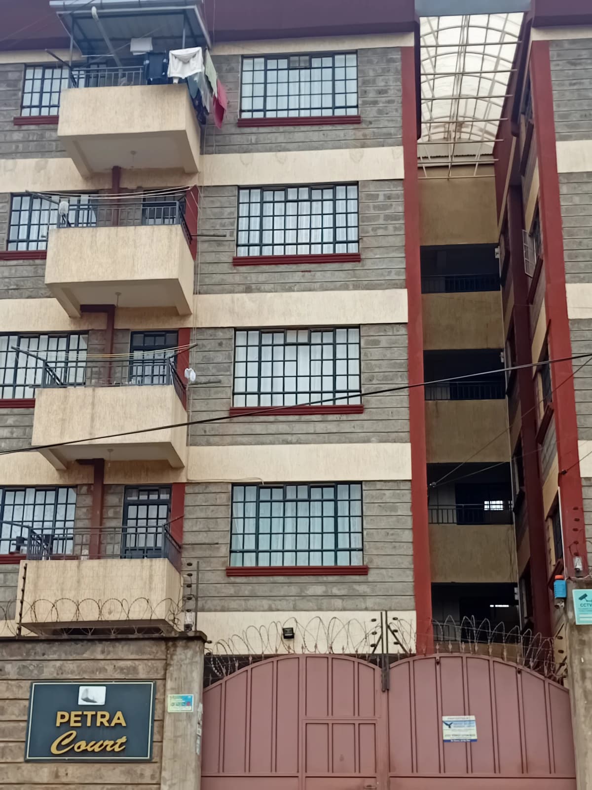Multi-story residential building facade with balconies and entrance gate