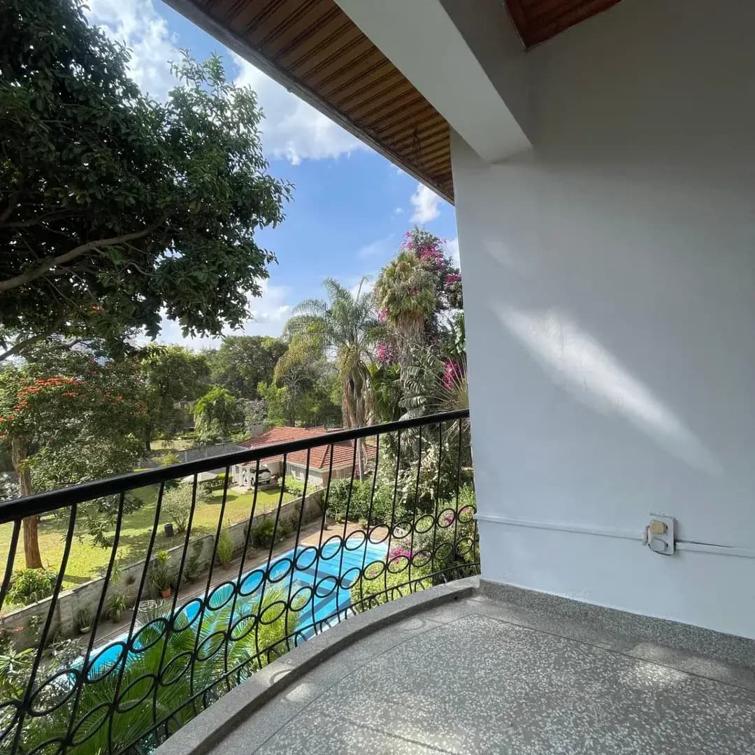 Spacious balcony overlooking lush garden and pool area