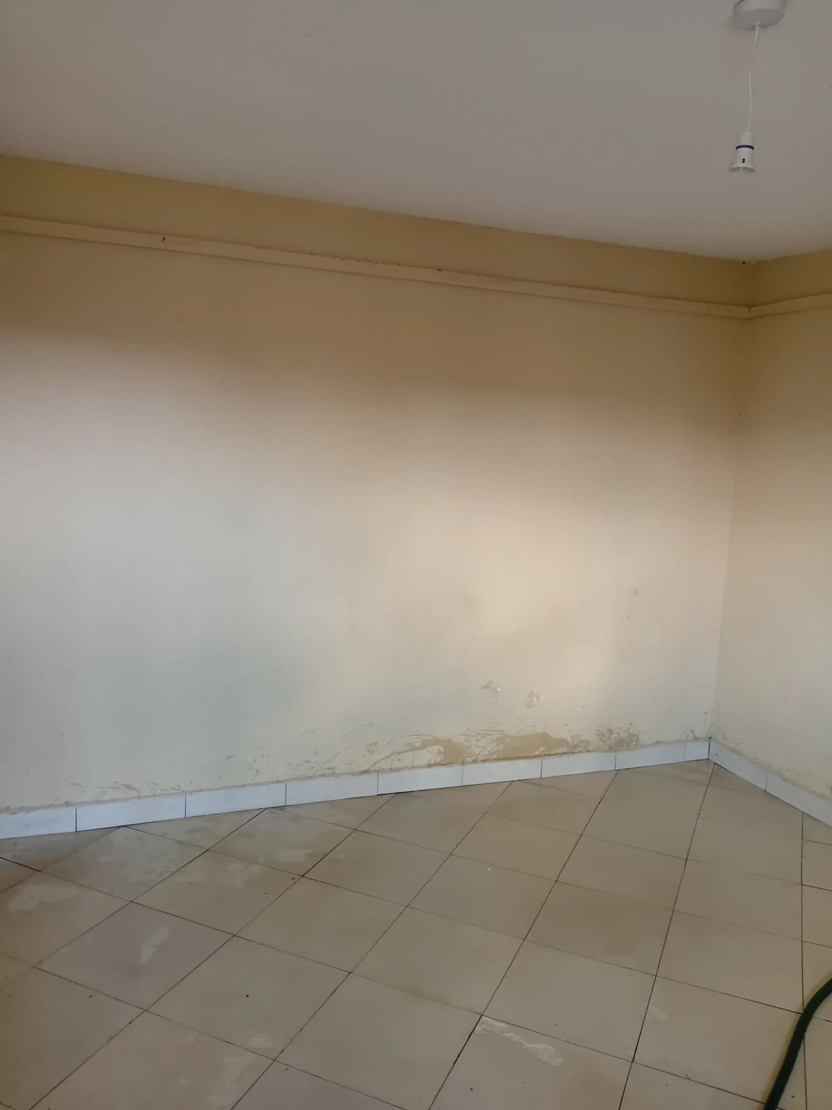Empty room with tiled floor and plain walls