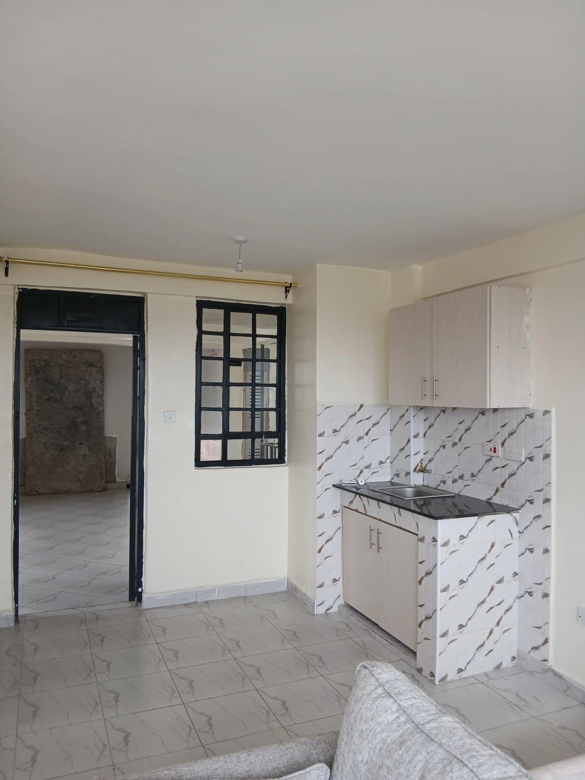 Open-plan kitchen with marble backsplash and adjacent living area
