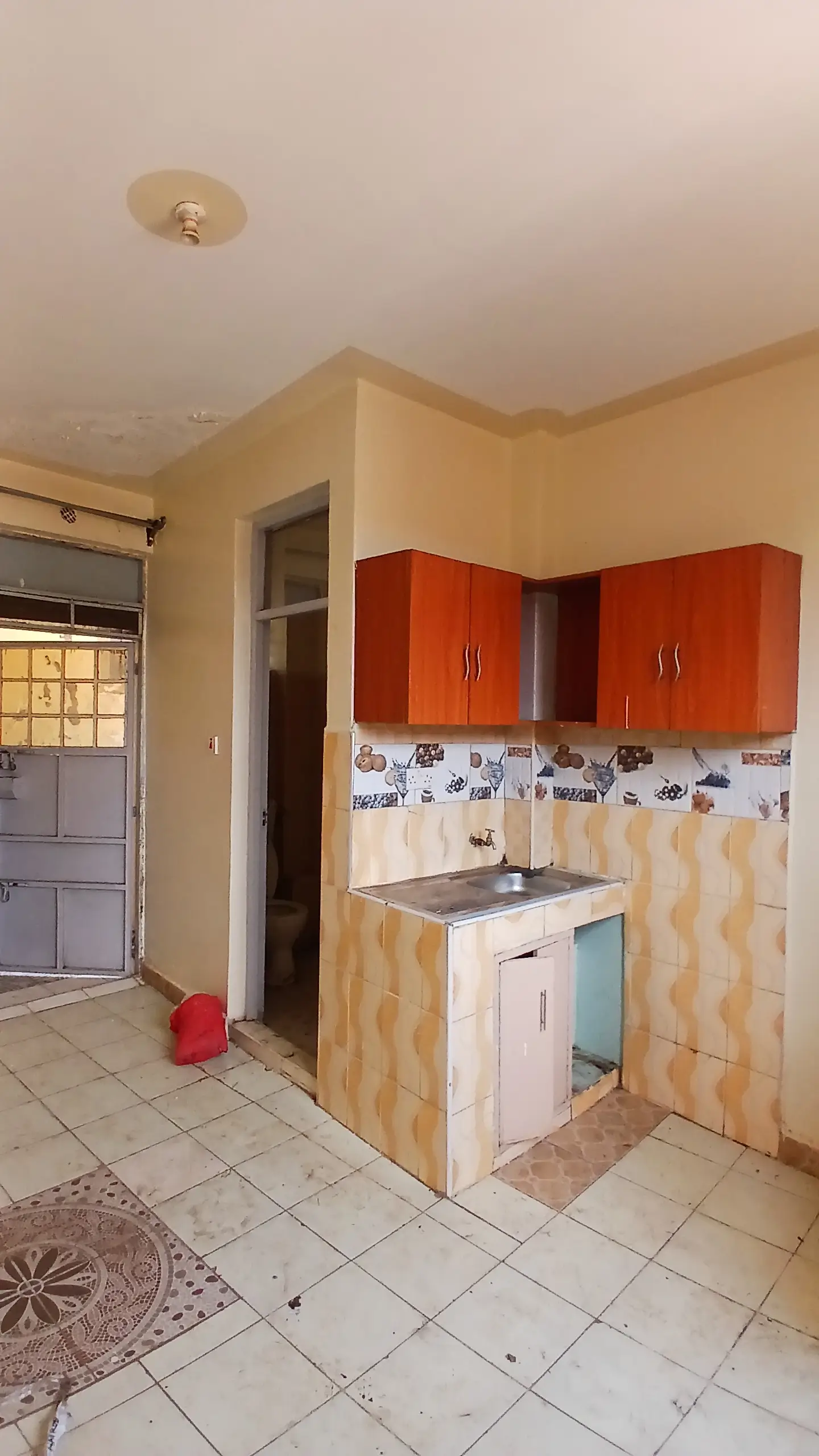 Compact kitchen with red cabinets and tile backsplash