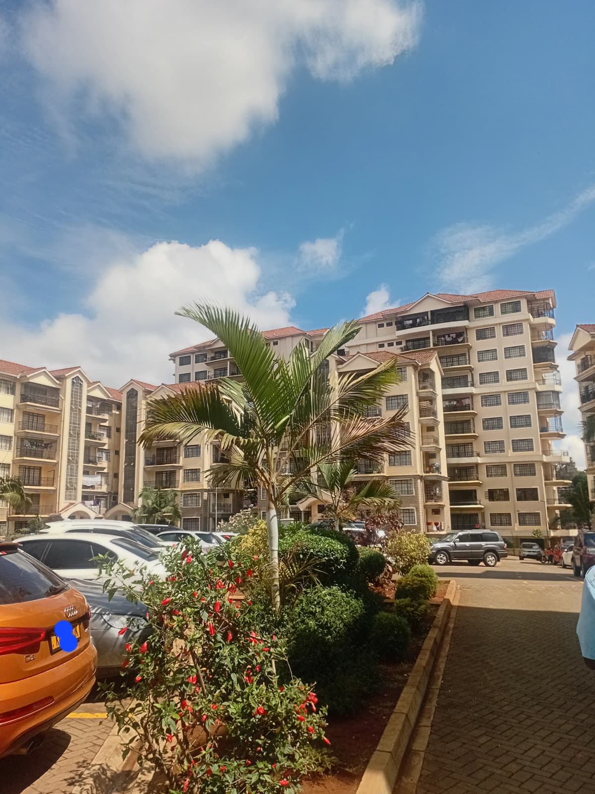 Multi-story residential buildings with landscaped parking compound