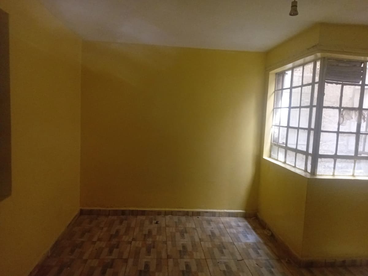 Empty bedroom with yellow walls and wooden flooring