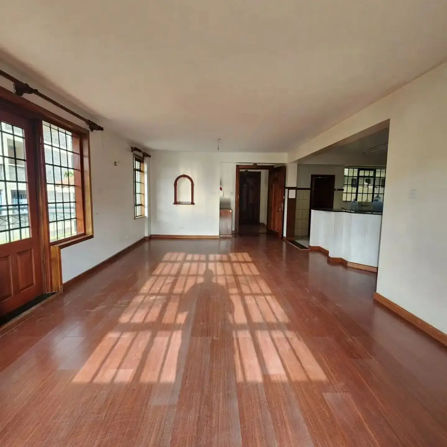 Spacious open-plan living area with wooden flooring and natural light