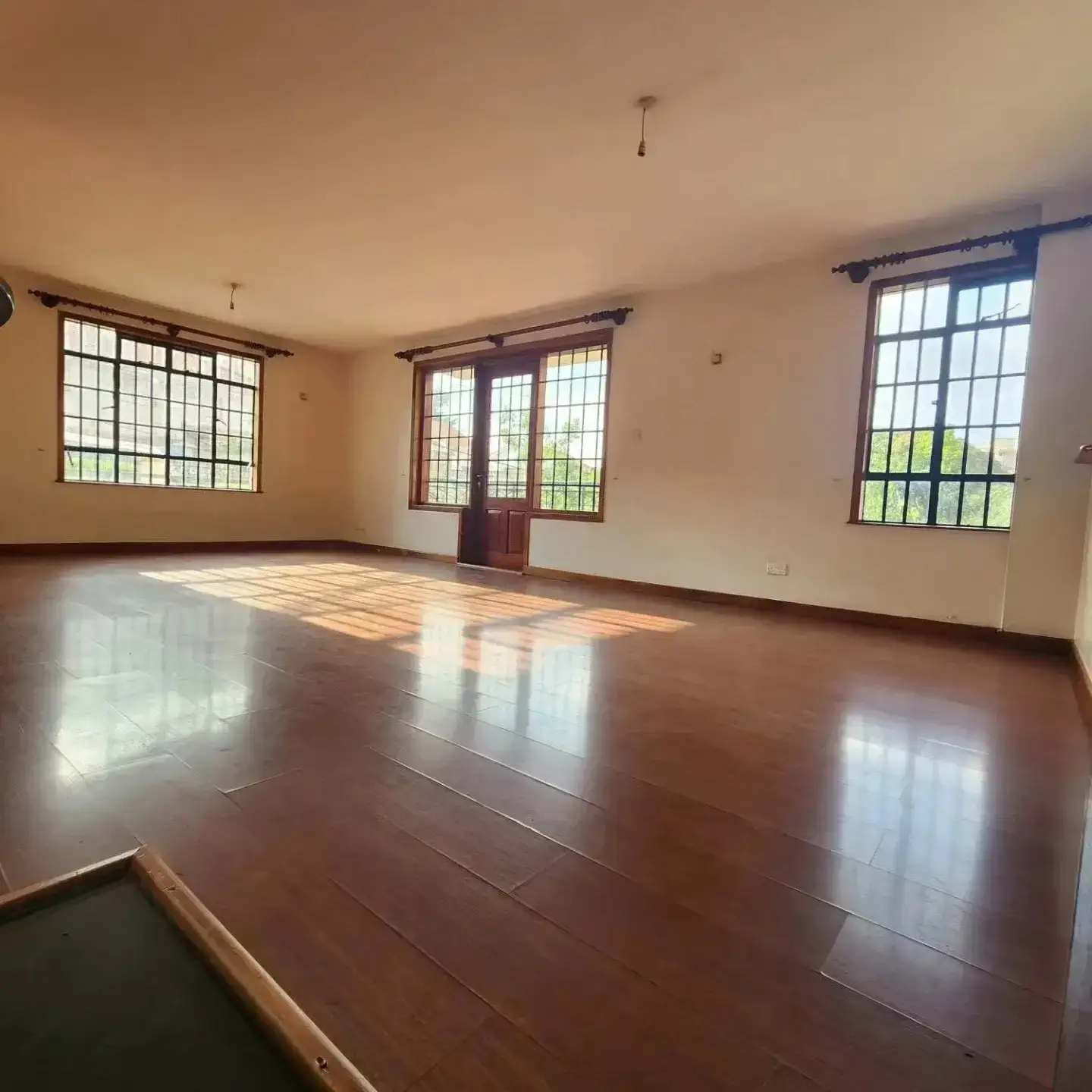 Spacious living room with polished wood floors and natural light