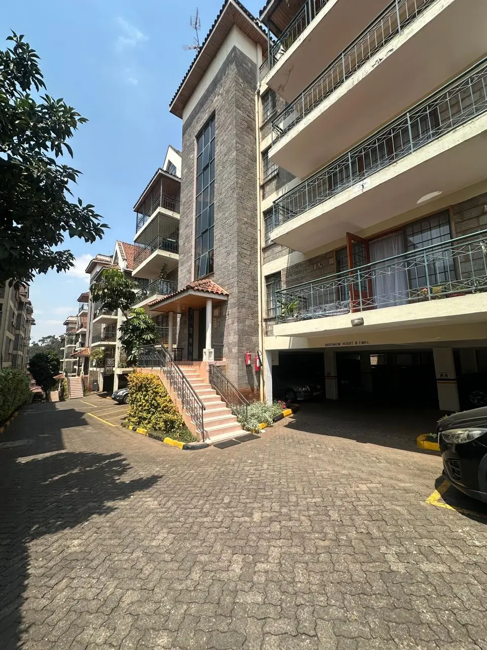 Multi-story residential building facade with ground-level parking entrance