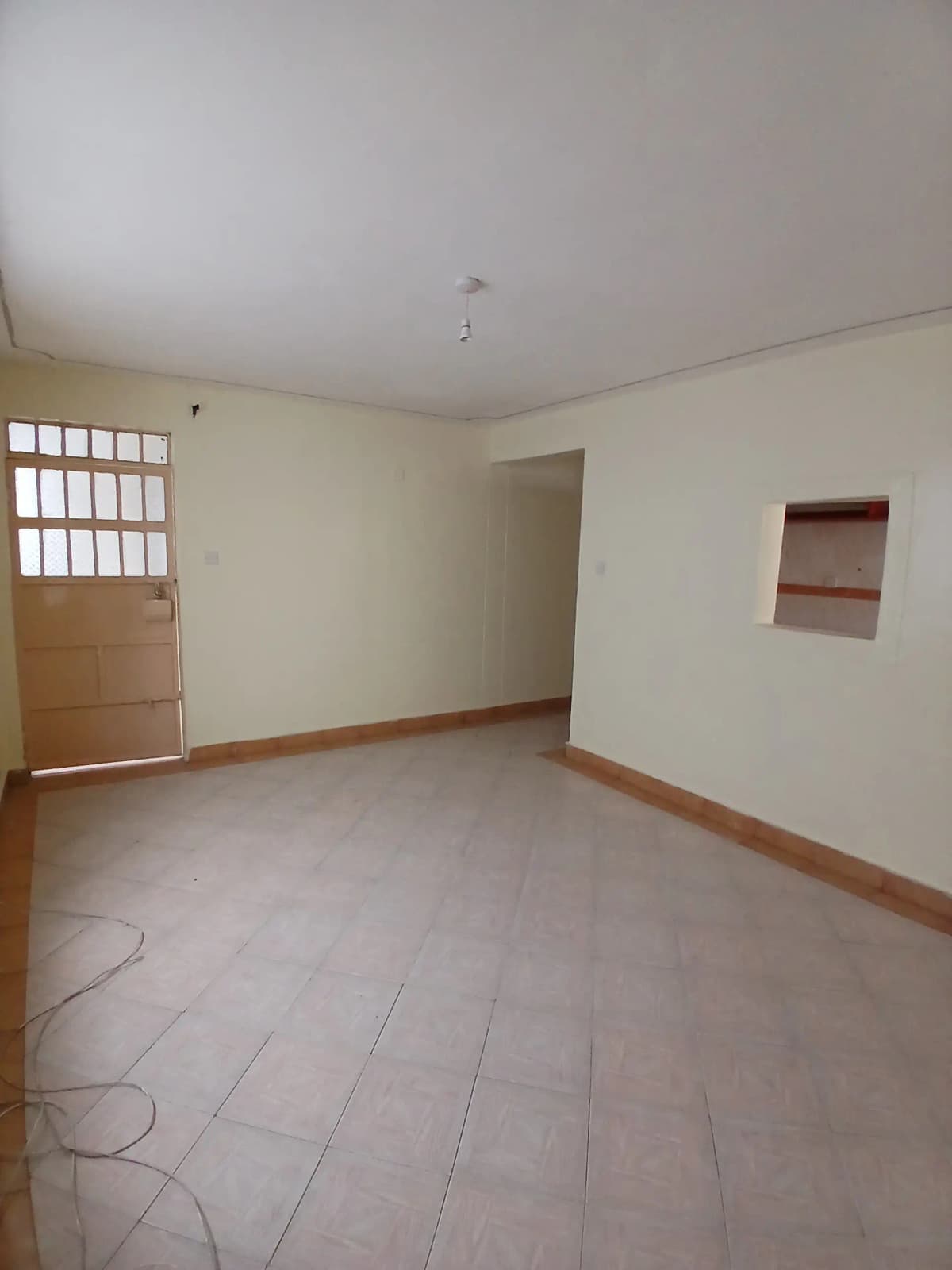 Empty living room with wooden trim and tiled flooring