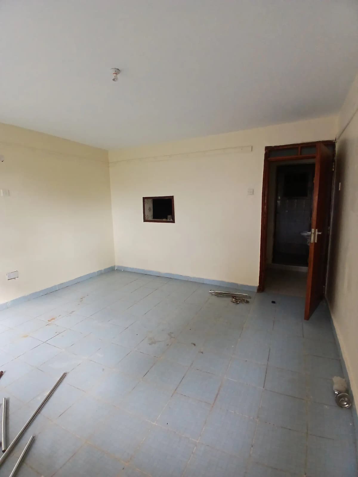 Empty living room with cream walls and gray tile flooring