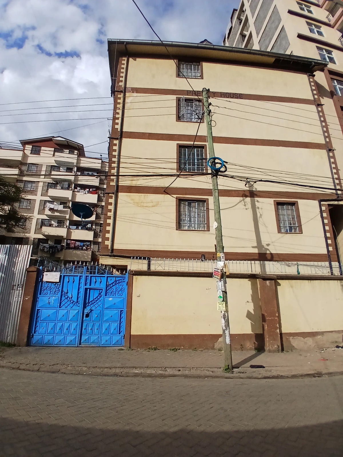 Multi-story residential building facade with blue gate entrance