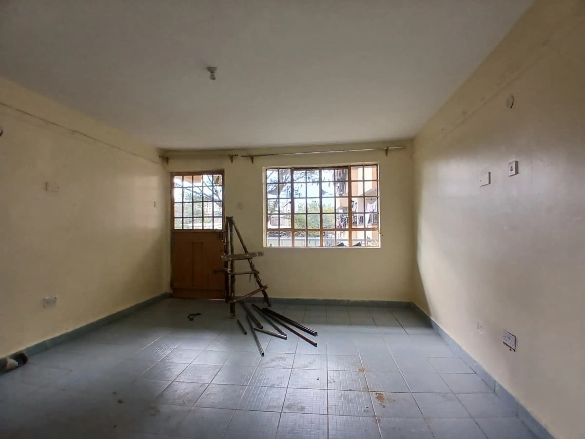 Empty living room with tiled floor and barred windows