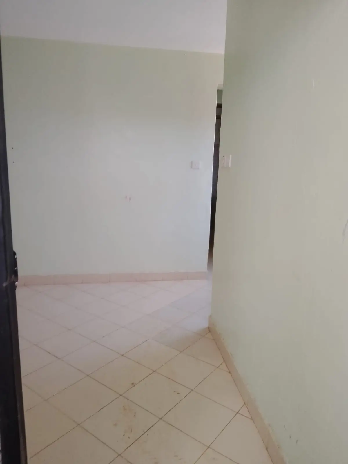 Empty hallway with tiled flooring and plain walls