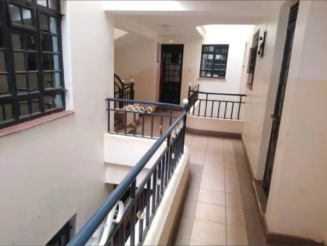 Multi-level corridor with metal railings and tiled flooring