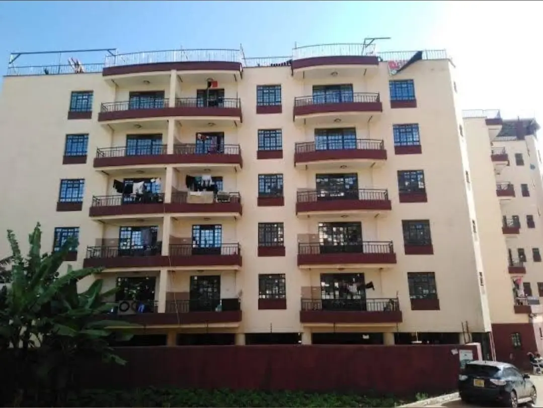 Multi-story residential building facade with balconies and ground parking