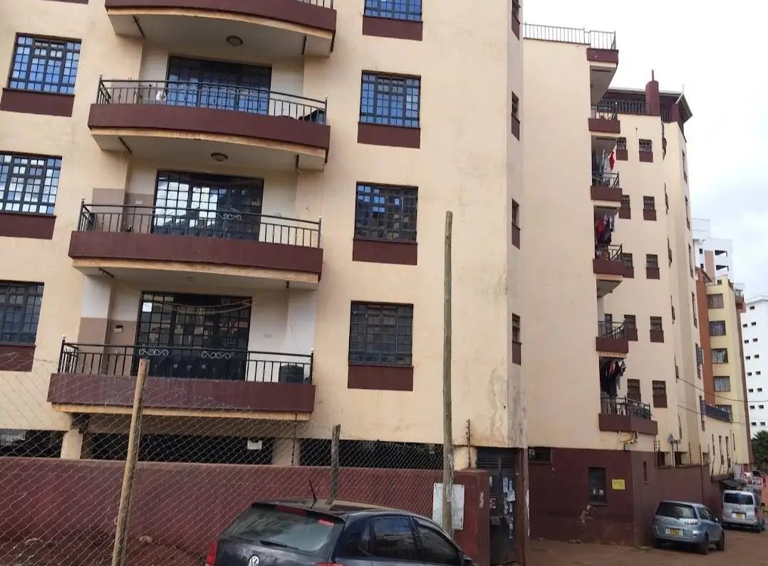 Multi-story residential building facade with balconies and parking
