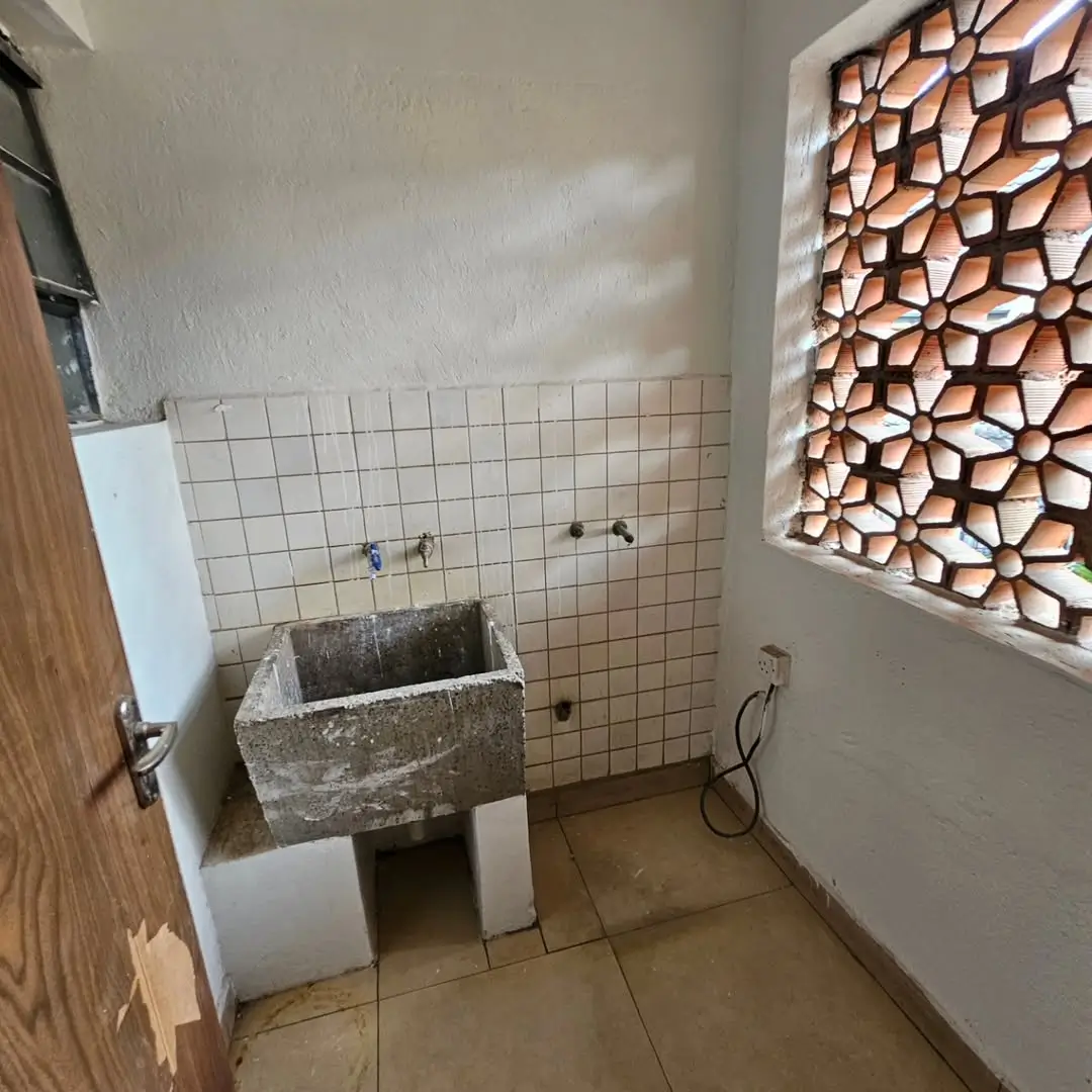 Utility room with concrete sink and tiled walls