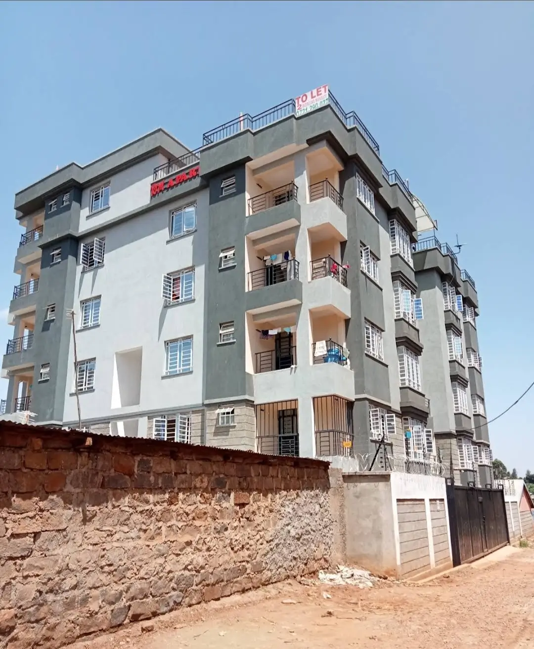 Multi-story residential apartment building with balconies and gate