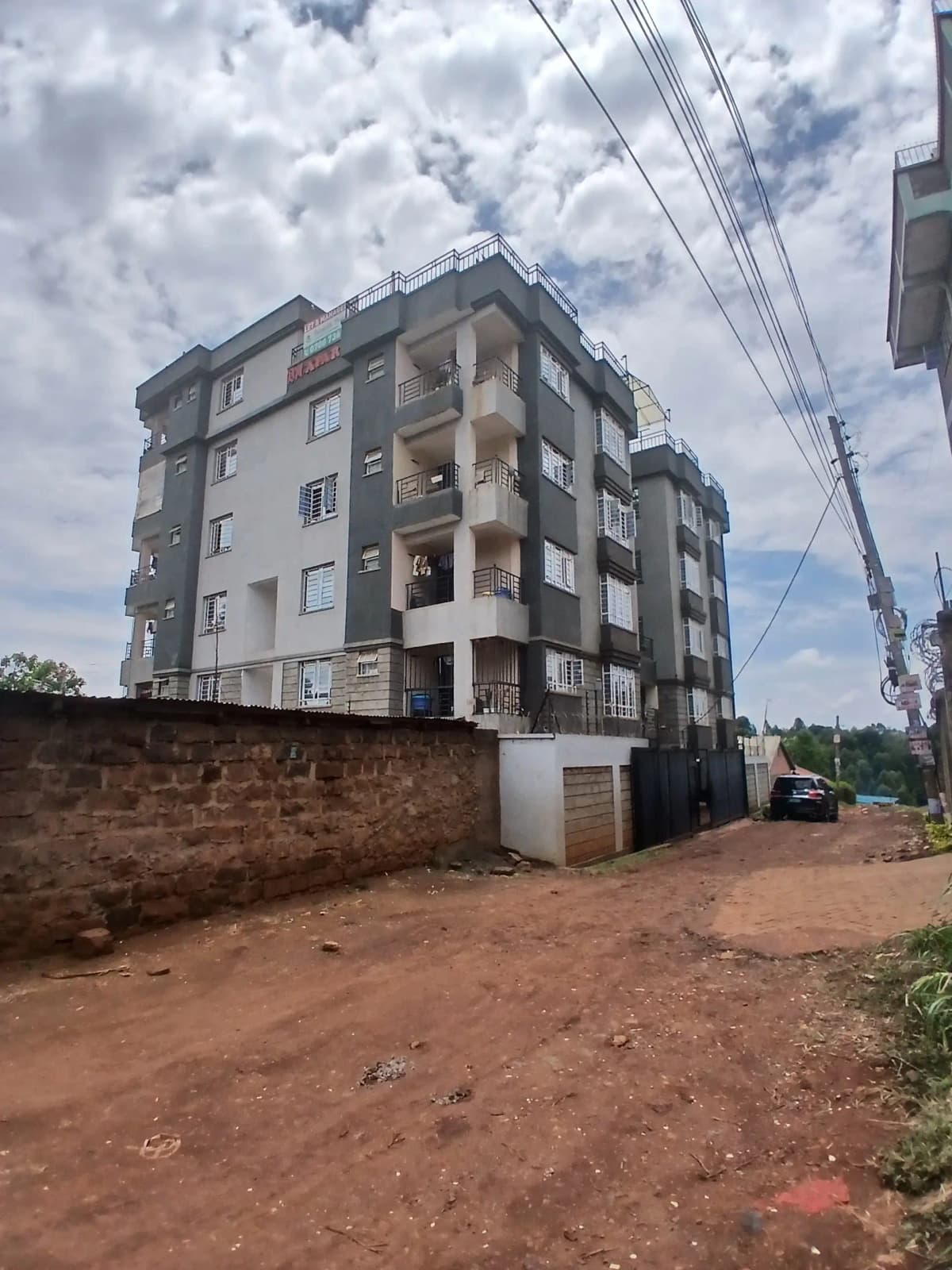 Multi-story residential building facade with red soil compound