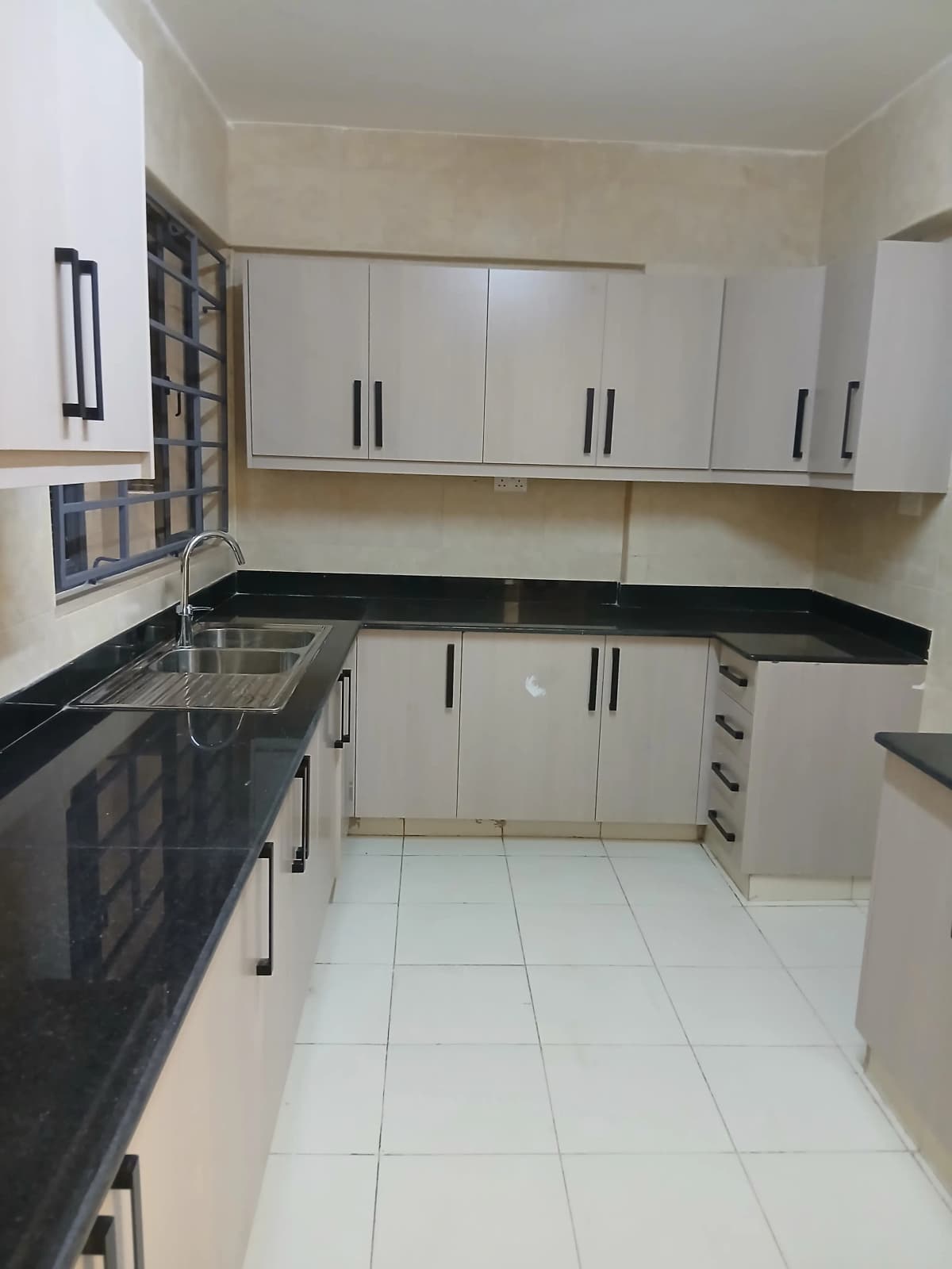 Modern kitchen with white cabinetry and black countertops